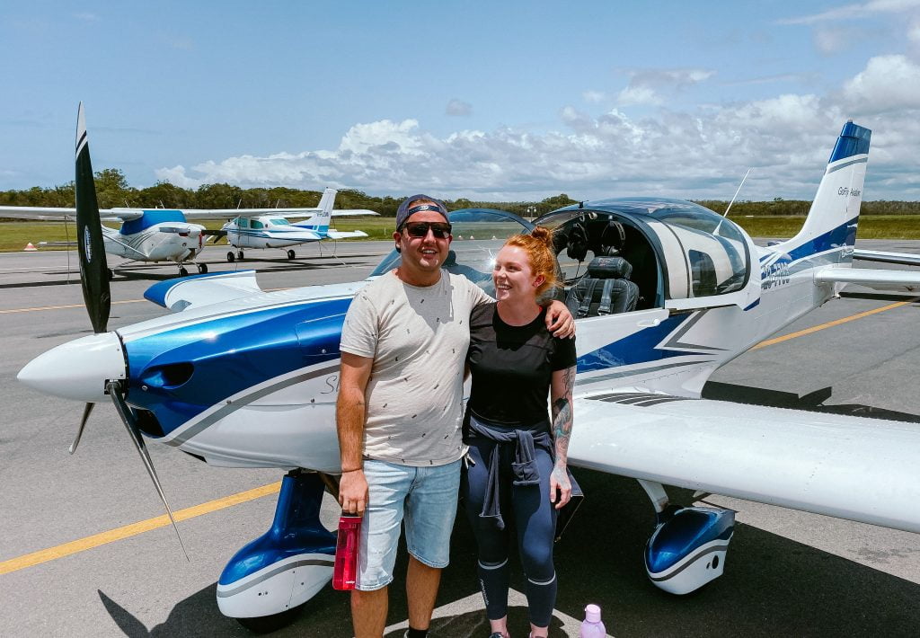 wide frame couple in front of Sling aircraft
